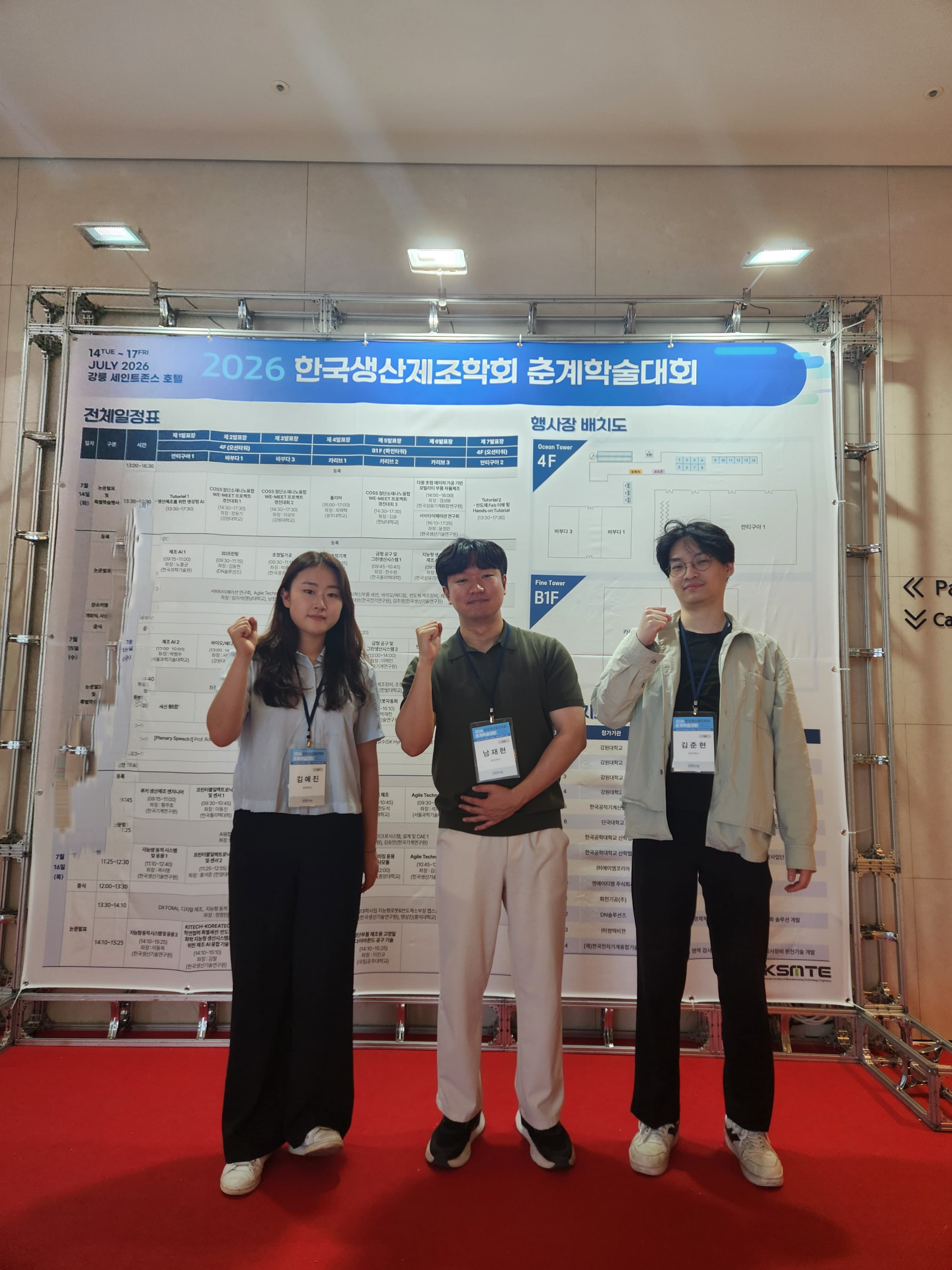 2026 한국생산제조학회 춘계학술대회 안내판 앞에 선 NIML 구성원 세 명